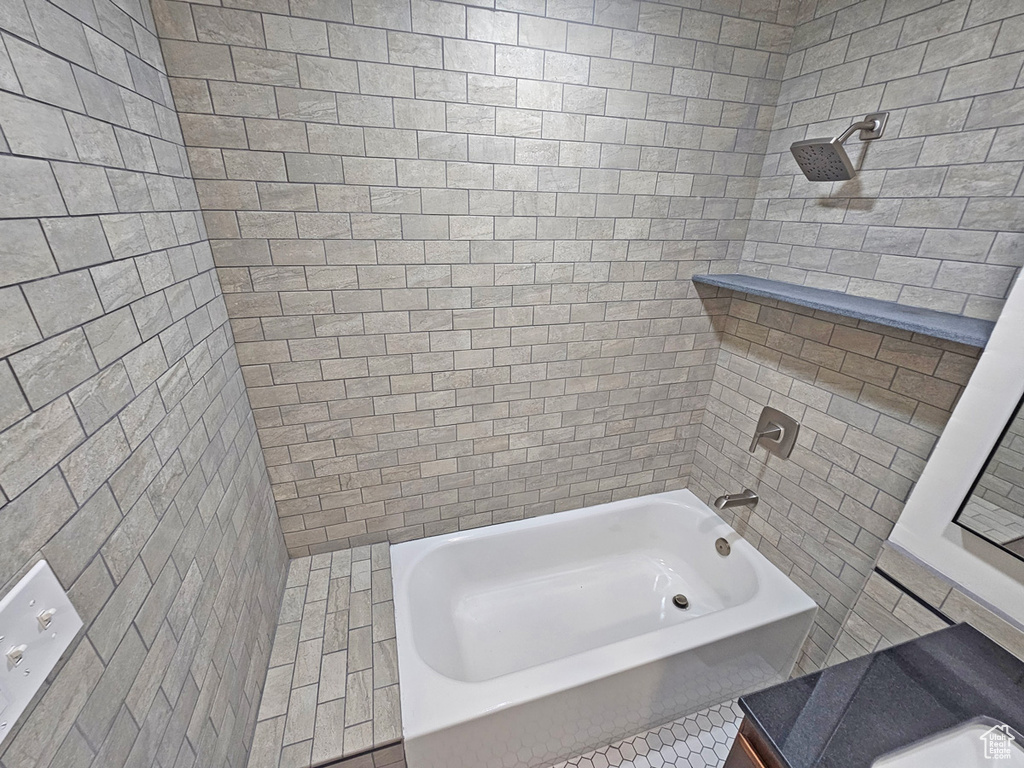 Bathroom with tile walls and shower / washtub combination