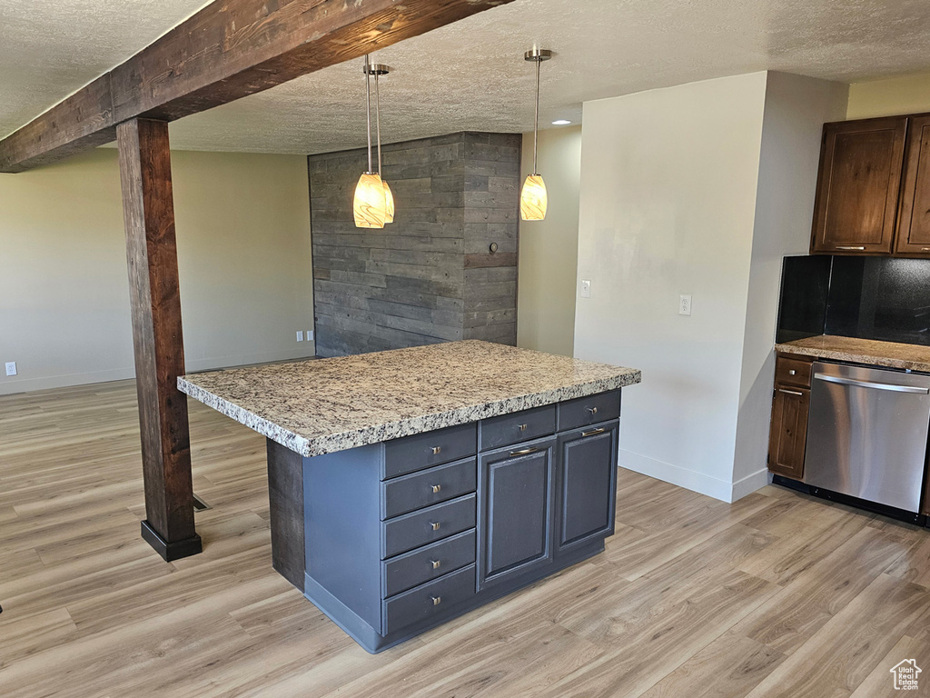 Kitchen featuring dishwasher, a textured ceiling, light wood-type flooring, pendant lighting, and a center island