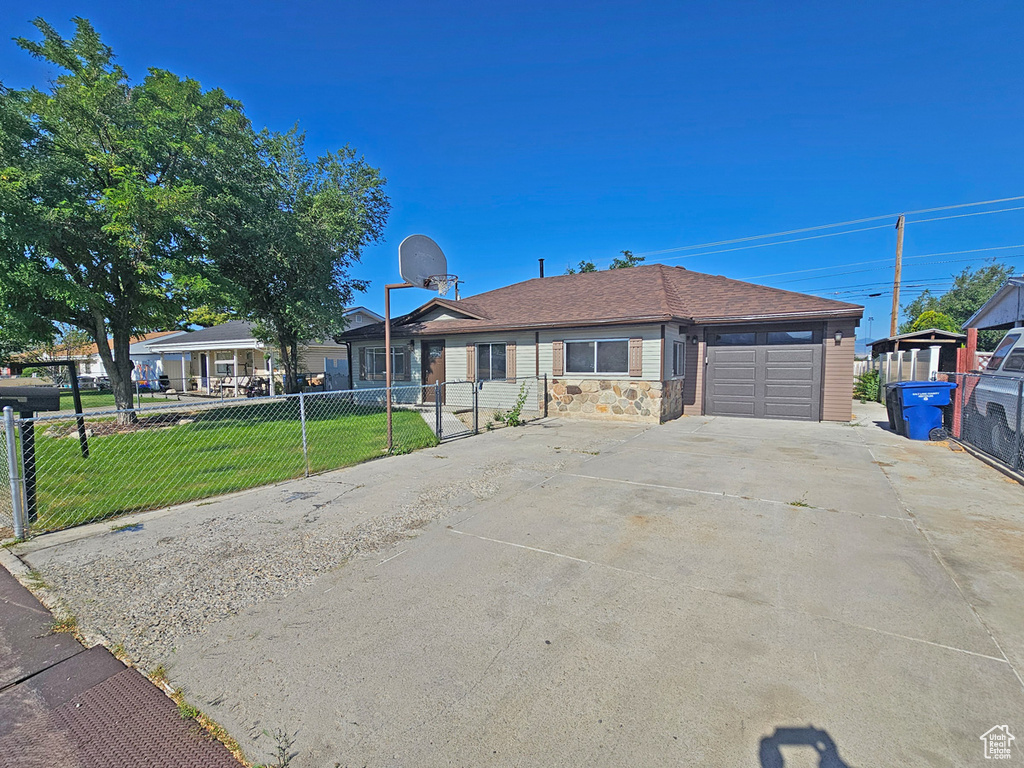 Ranch-style home featuring a garage and concrete driveway