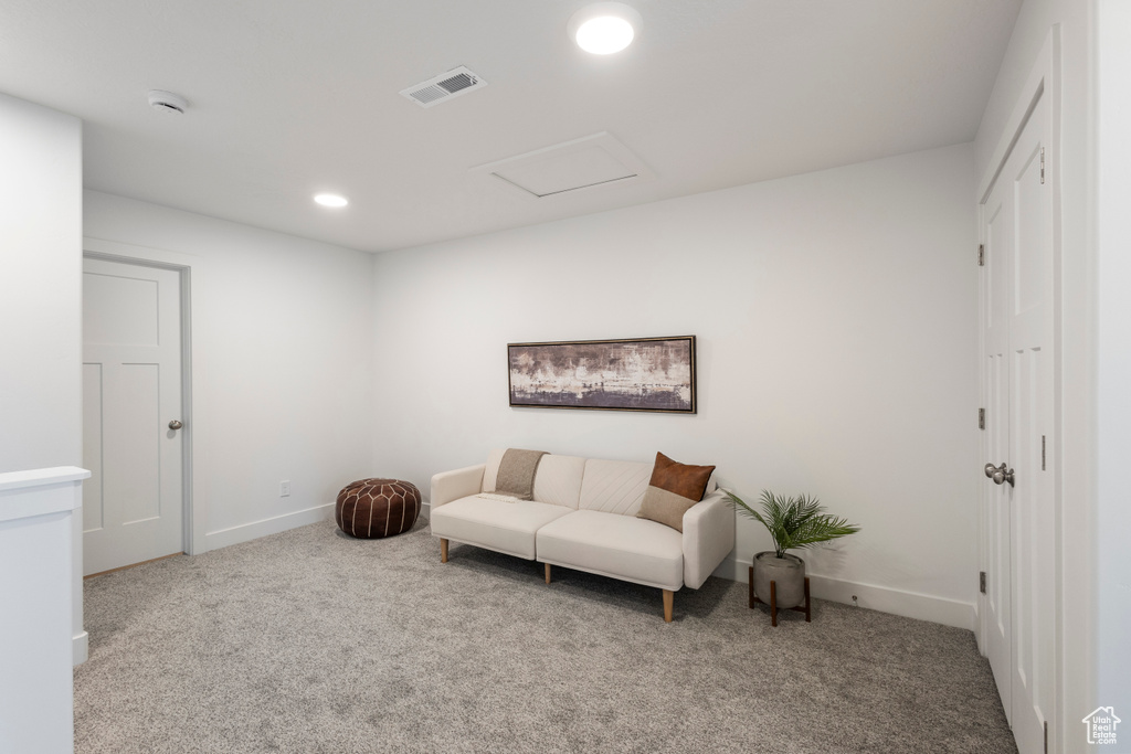 Living area with carpet, recessed lighting, and attic access