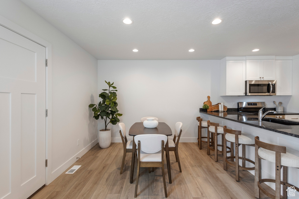 Dining space featuring light wood-type flooring and recessed lighting