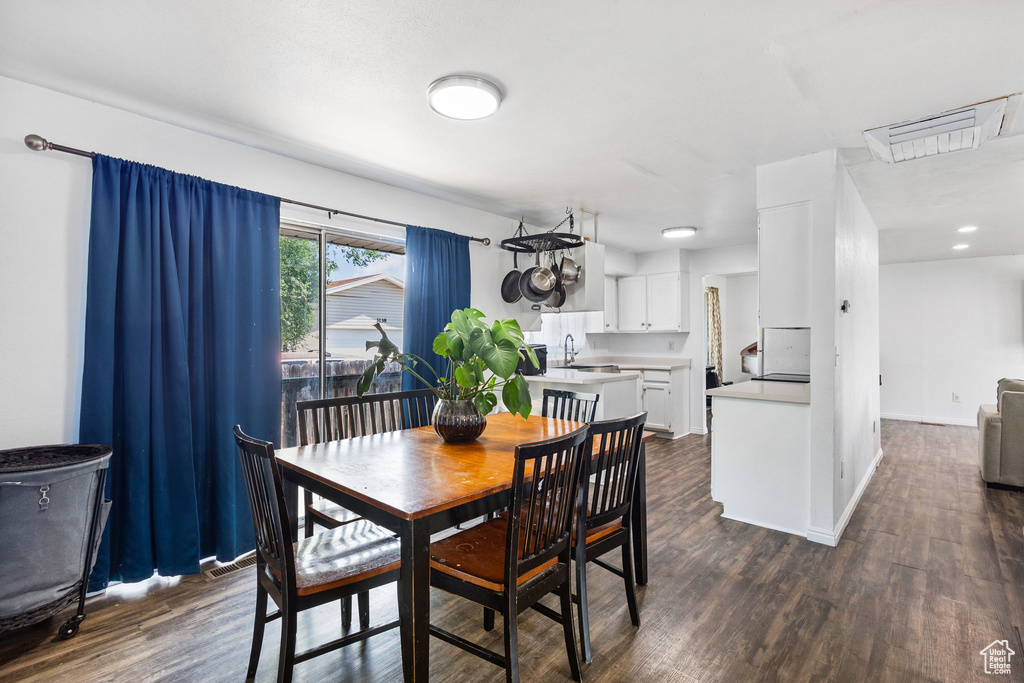 Dining space with dark wood-style floors and baseboards