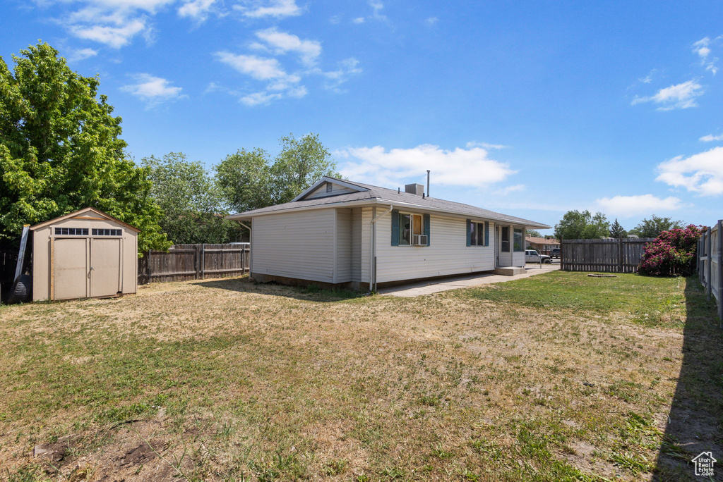 Fenced backyard featuring a storage shed and a patio area