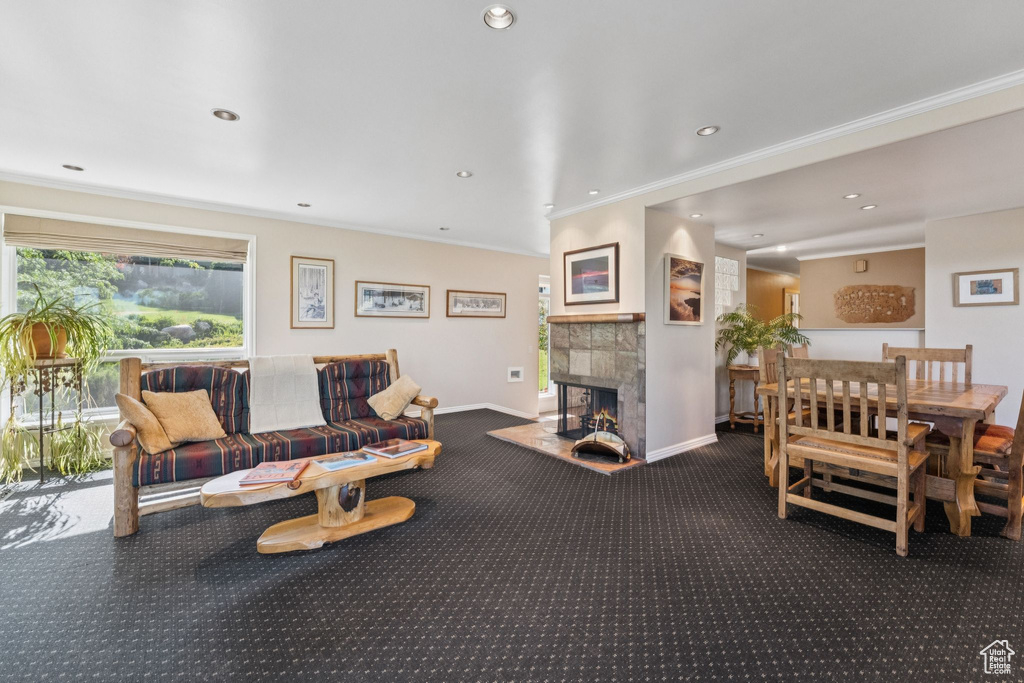 Living room featuring carpet, crown molding, a fireplace, and recessed lighting