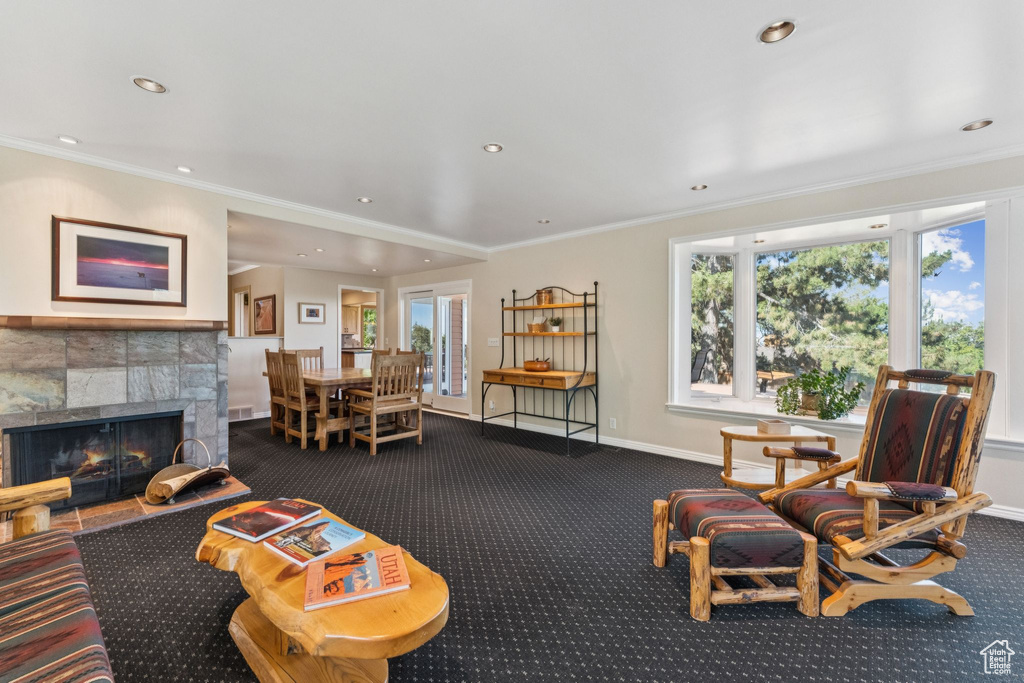 Living room featuring dark colored carpet, recessed lighting, plenty of natural light, a fireplace, and crown molding