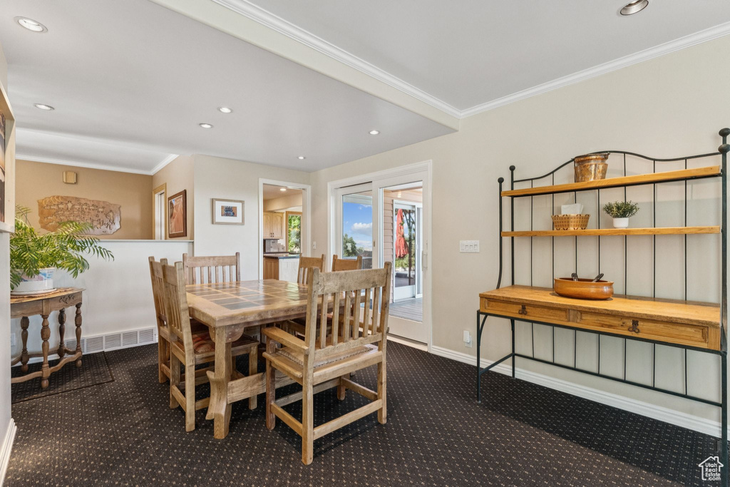 Dining area with carpet flooring, ornamental molding, and recessed lighting
