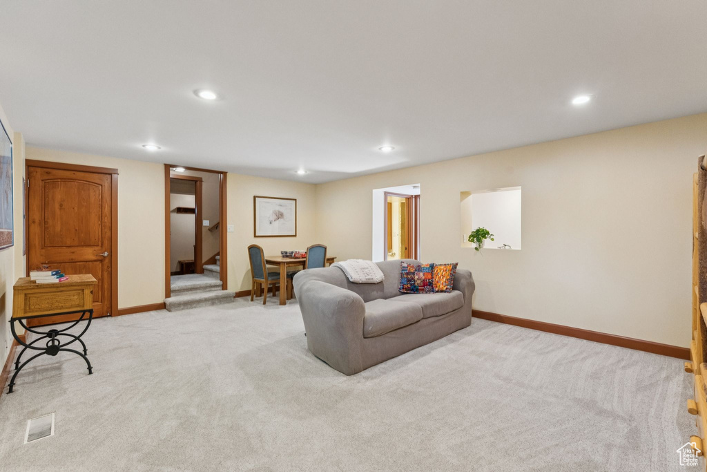 Living area featuring light carpet, recessed lighting, and stairway