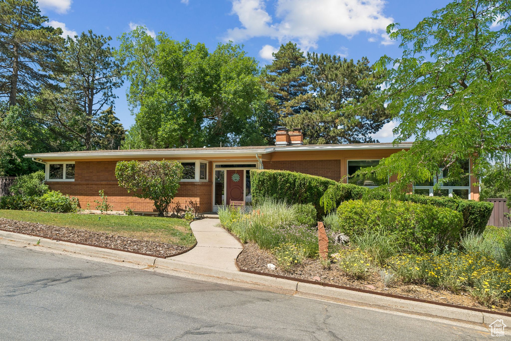 View of front of home with brick siding and a chimney