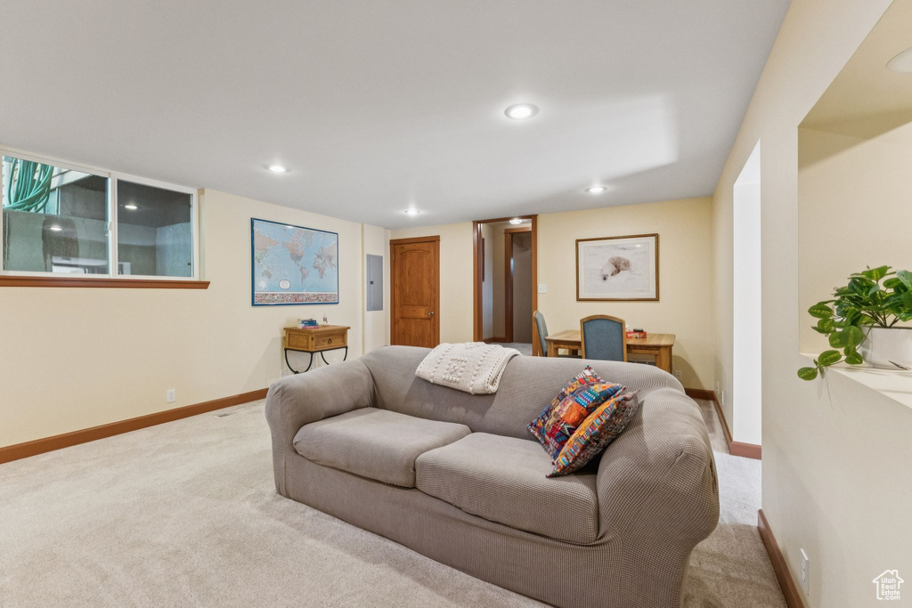Carpeted living room featuring electric panel and recessed lighting