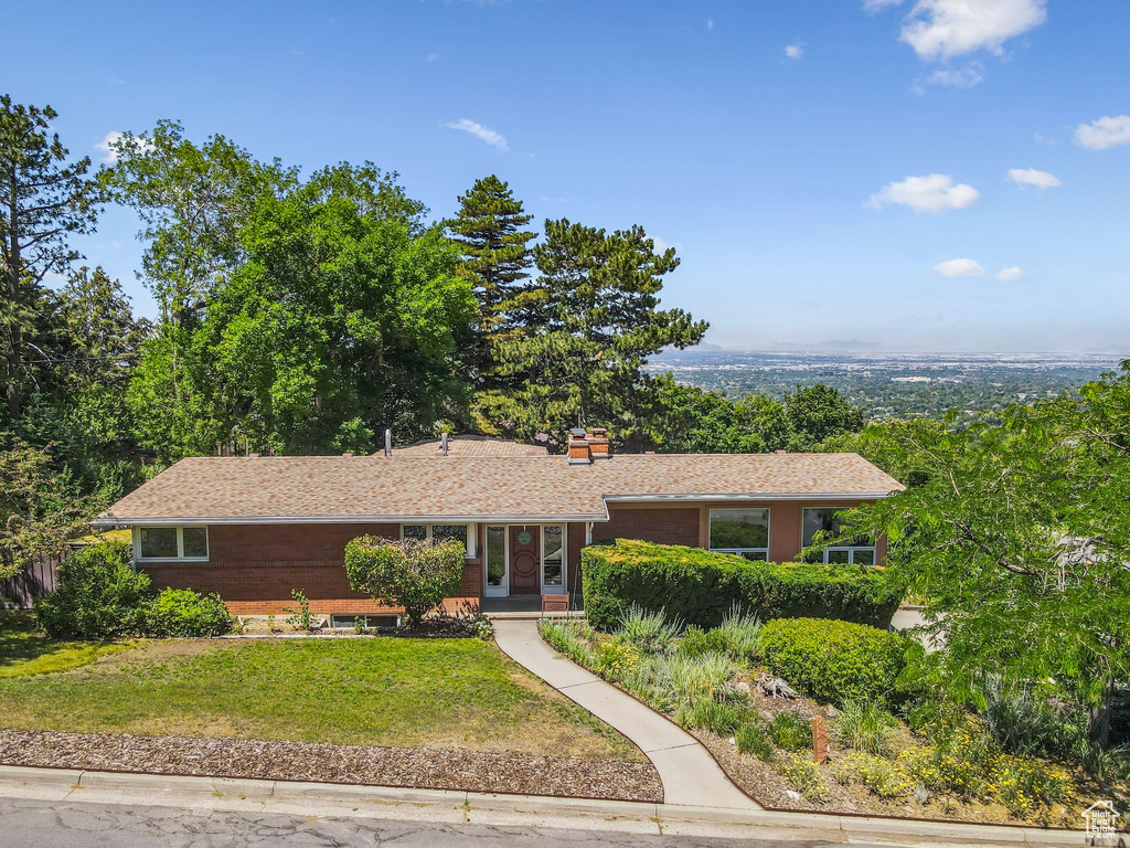 Ranch-style home with a front yard and a chimney