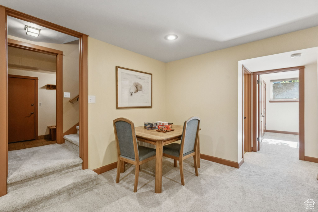 Dining area with light colored carpet and stairs