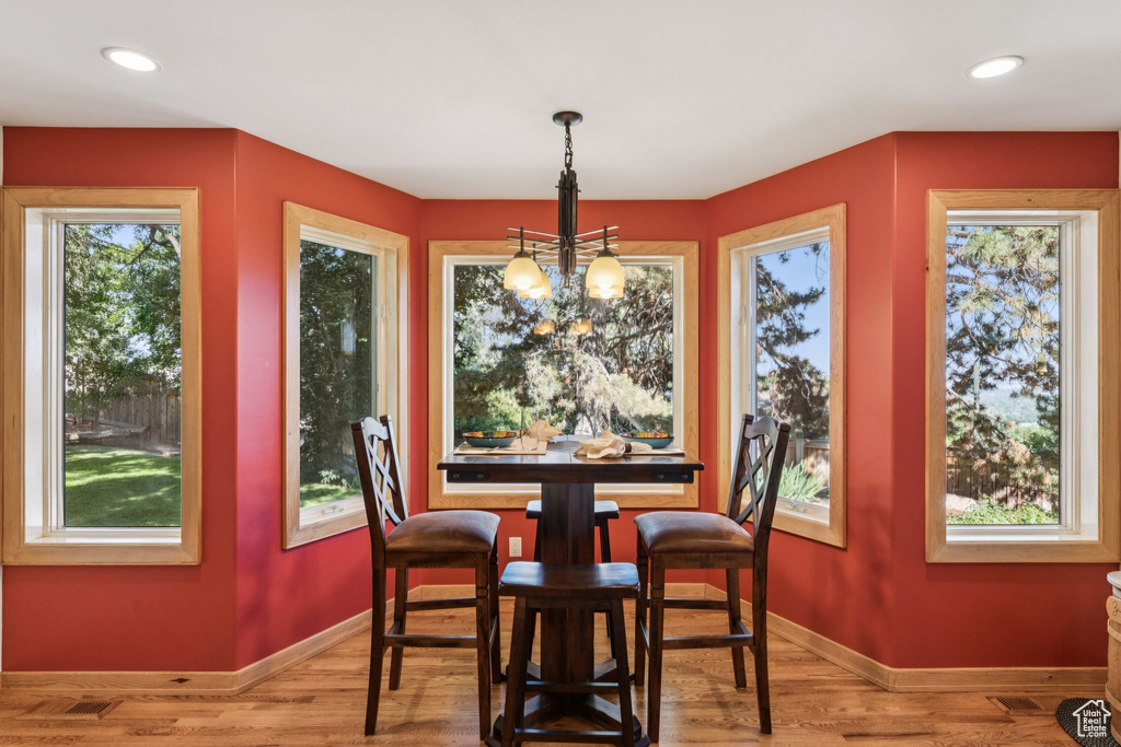 Dining room with a chandelier, wood finished floors, and recessed lighting