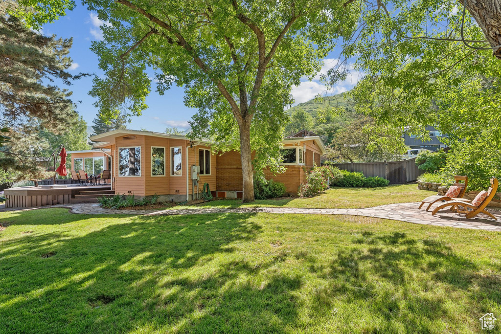 View of yard featuring a deck and a patio