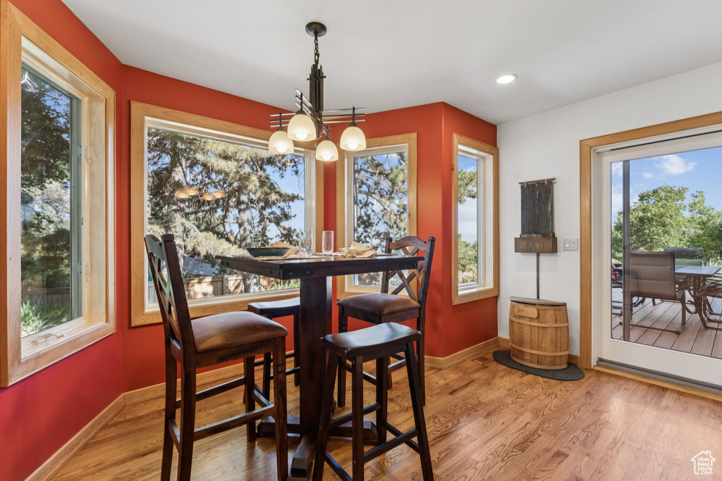 Dining room with wood finished floors, a chandelier, and recessed lighting