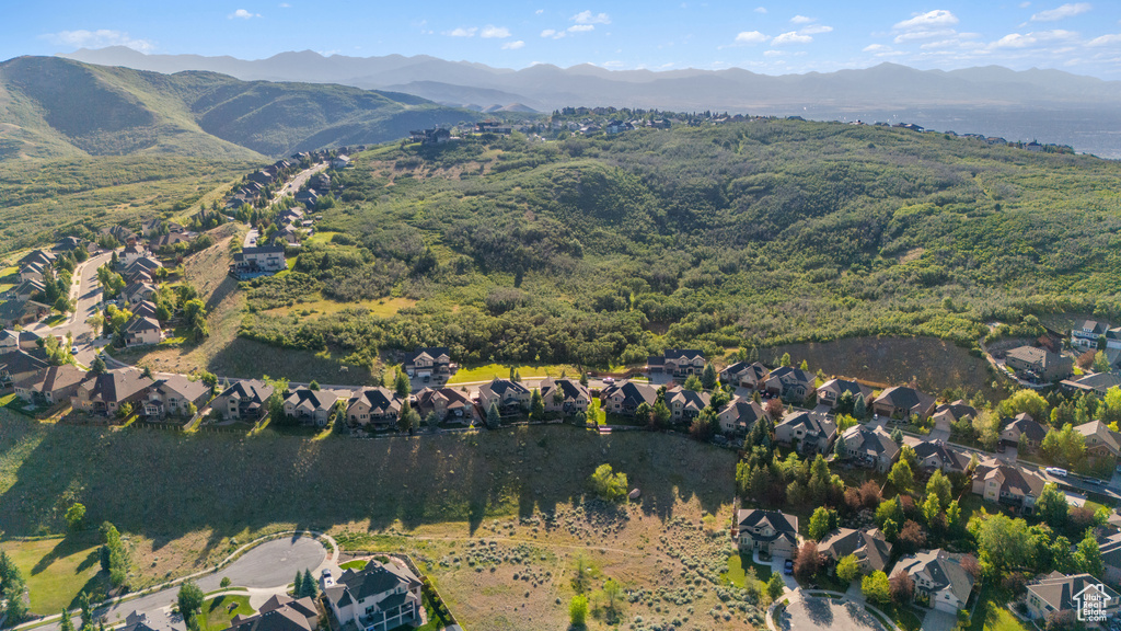 Aerial view of property and surrounding area featuring mountains and nearby suburban area