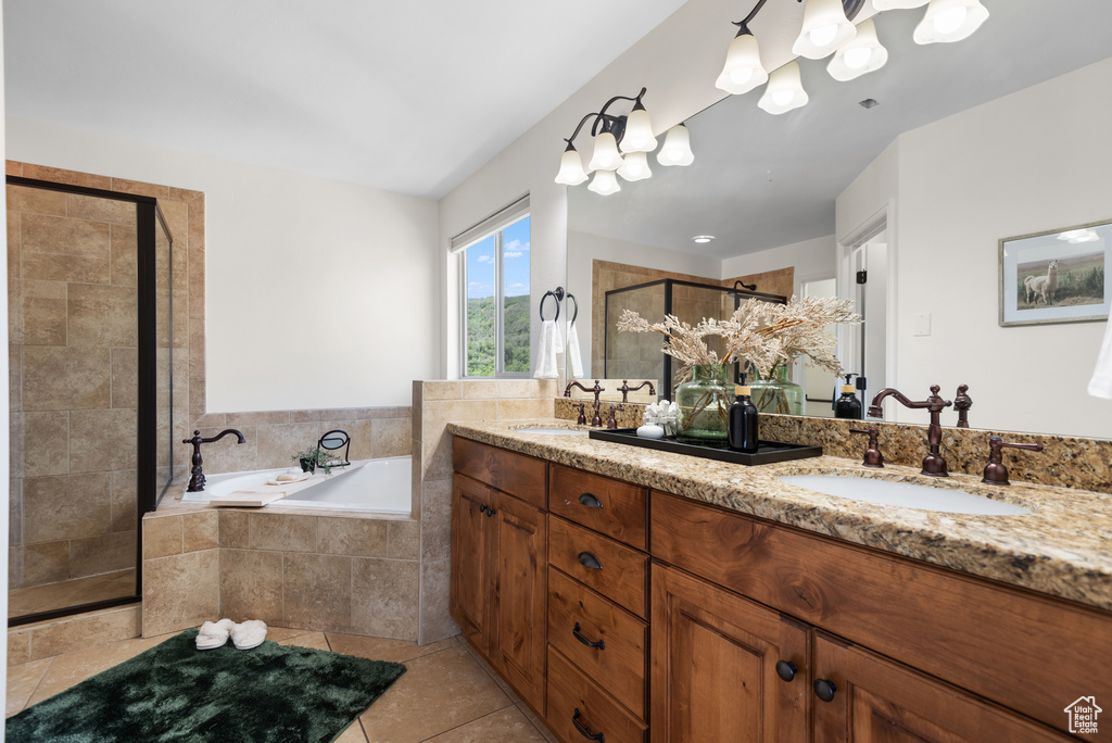Full bath featuring double vanity, a shower stall, a bath, tile patterned flooring, and a chandelier