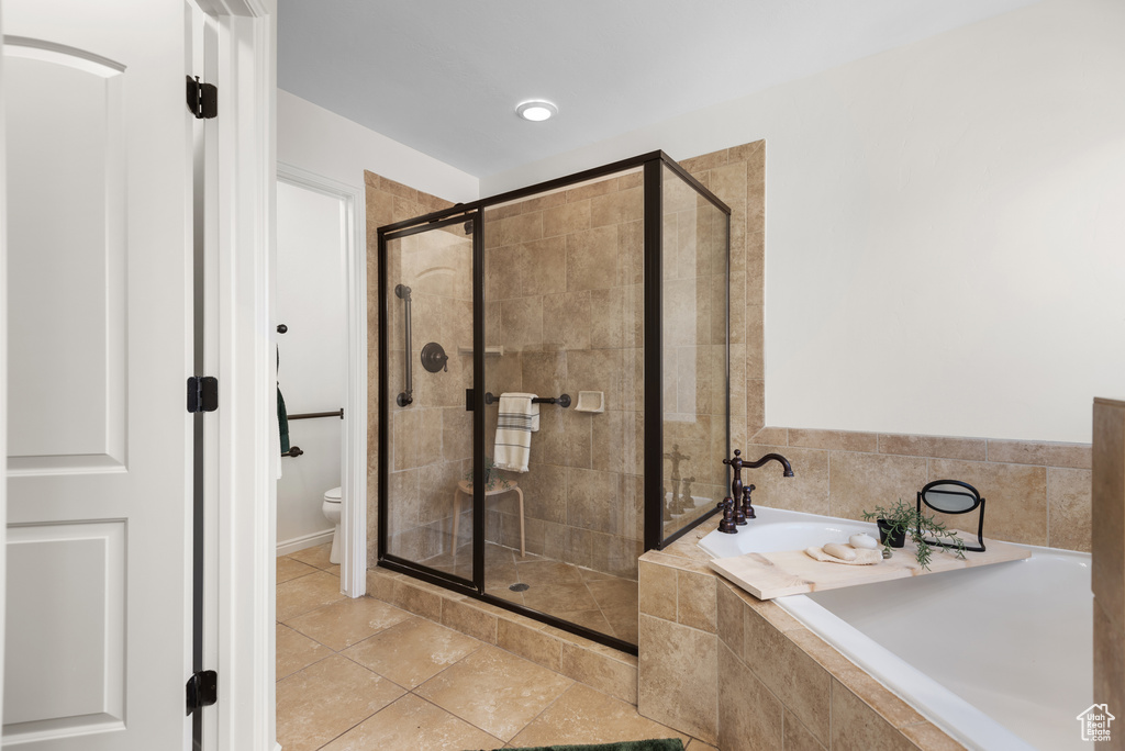 Full bathroom featuring a garden tub, a shower stall, and tile patterned flooring
