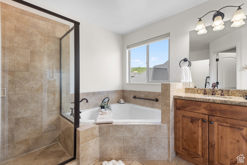 Full bath with vanity, a garden tub, and a stall shower