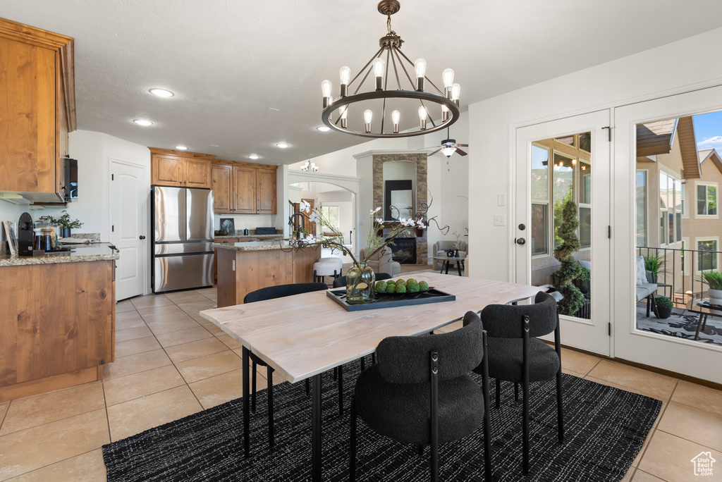 Dining space with a chandelier, light tile patterned floors, recessed lighting, and arched walkways