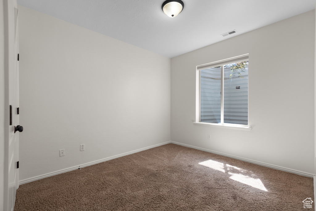 Carpeted spare room with baseboards