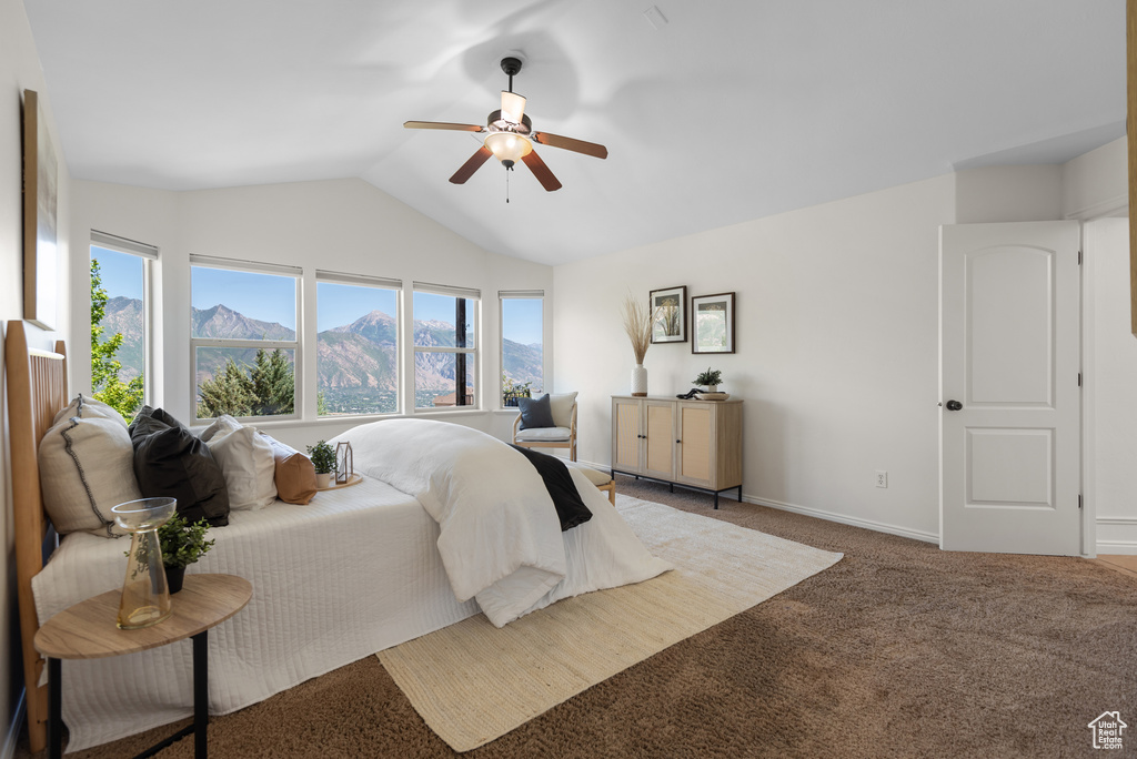 Carpeted bedroom featuring vaulted ceiling, a mountain view, and a ceiling fan