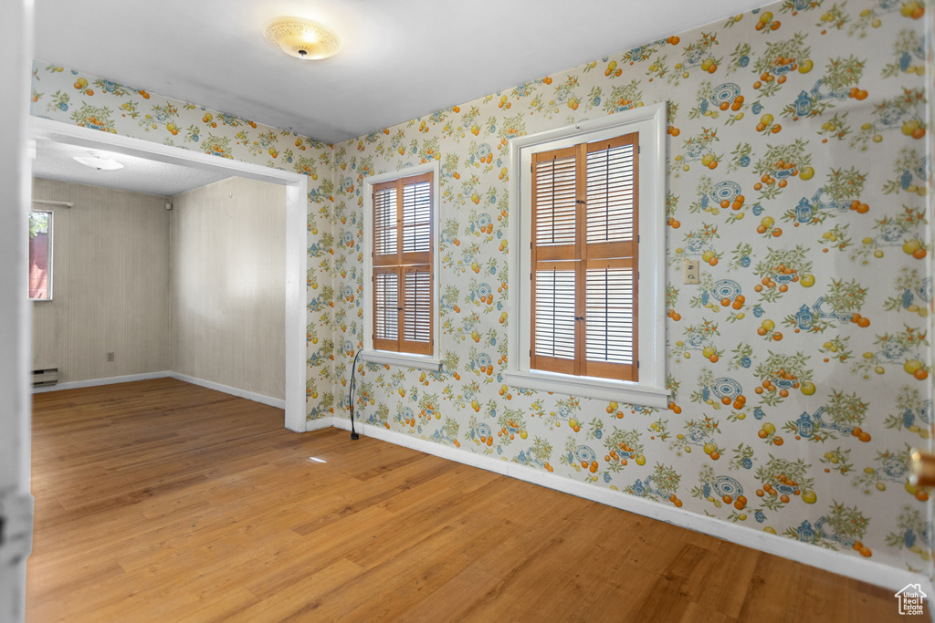 Empty room with light wood-style flooring and baseboard heating