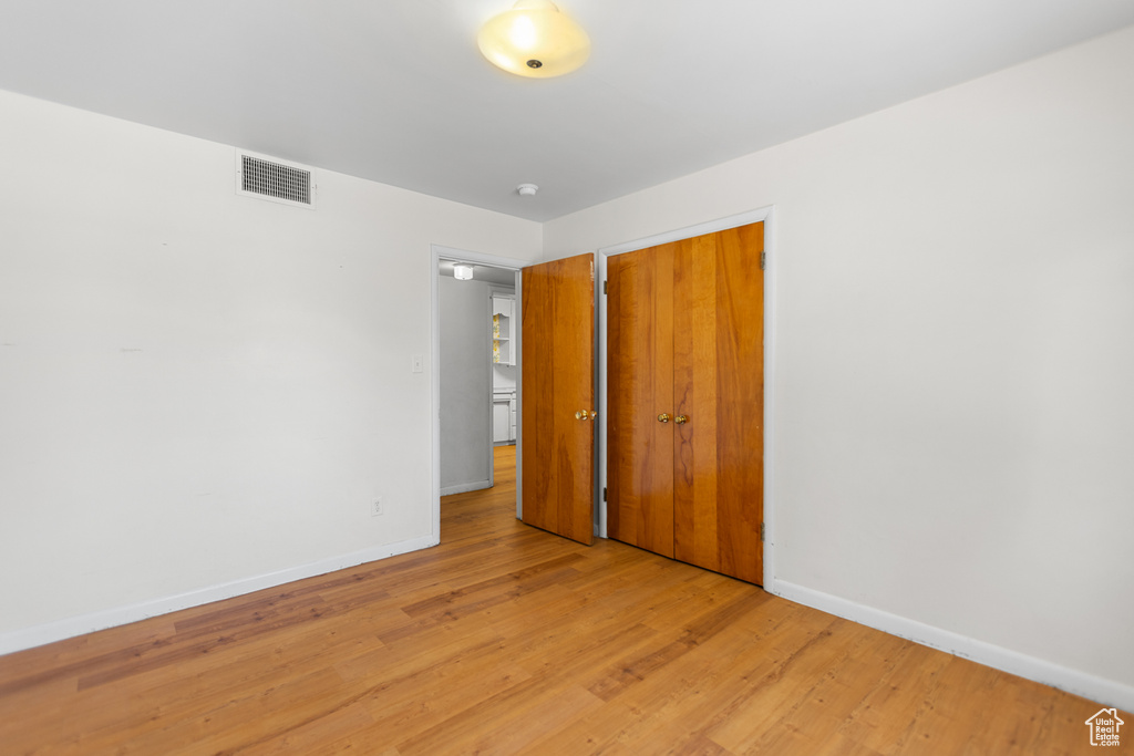 Unfurnished bedroom with light wood finished floors and a closet