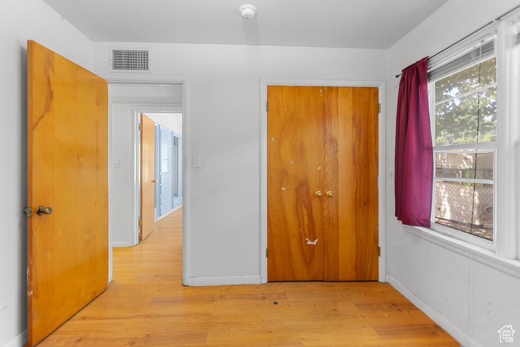 Unfurnished bedroom featuring light wood-type flooring and a closet
