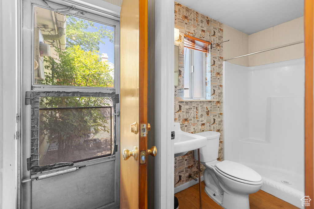 Bathroom featuring a shower stall and wood finished floors