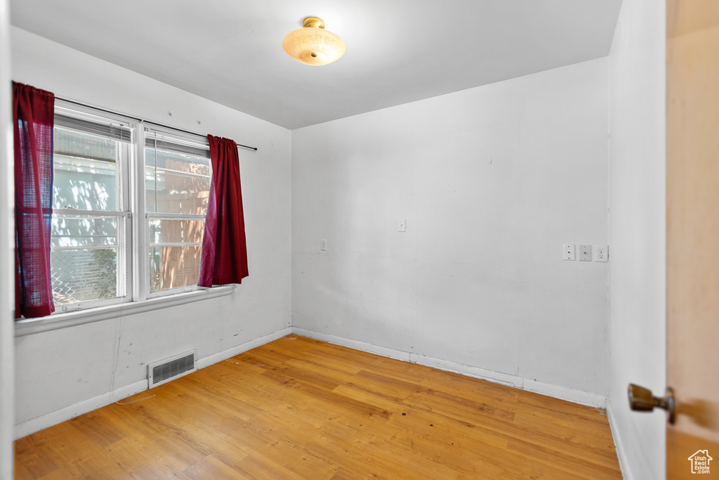 Unfurnished room with wood finished floors and baseboards