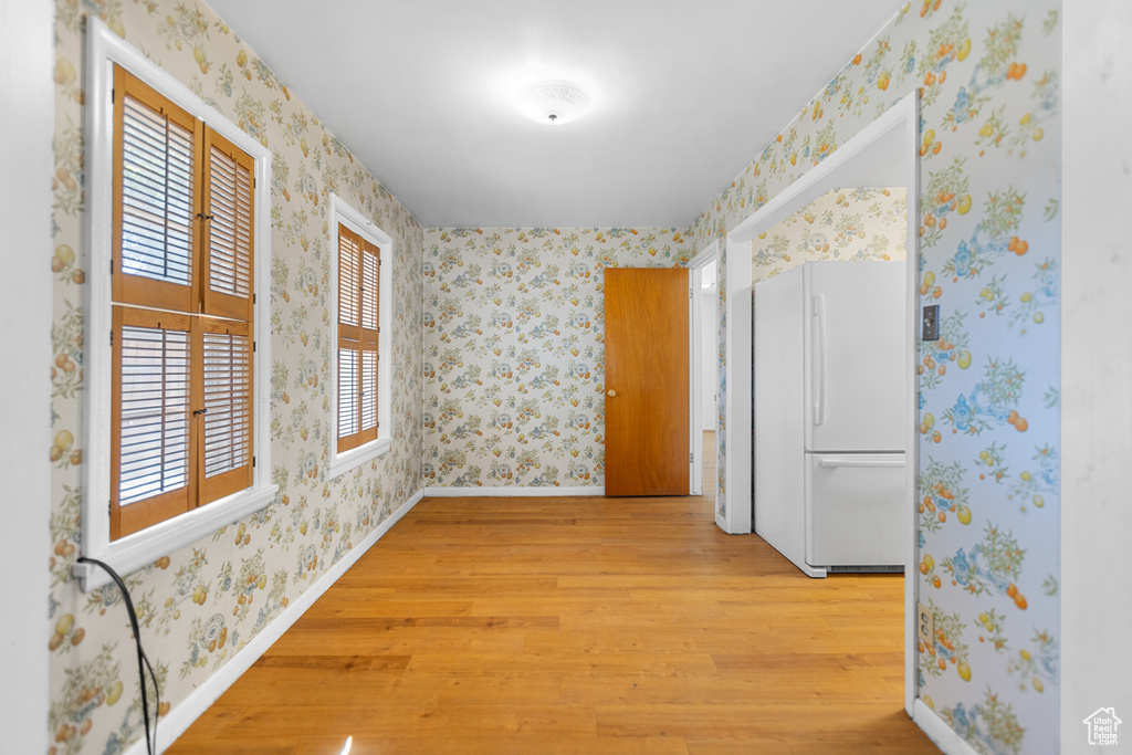 Spare room with light wood-style floors and wallpapered walls