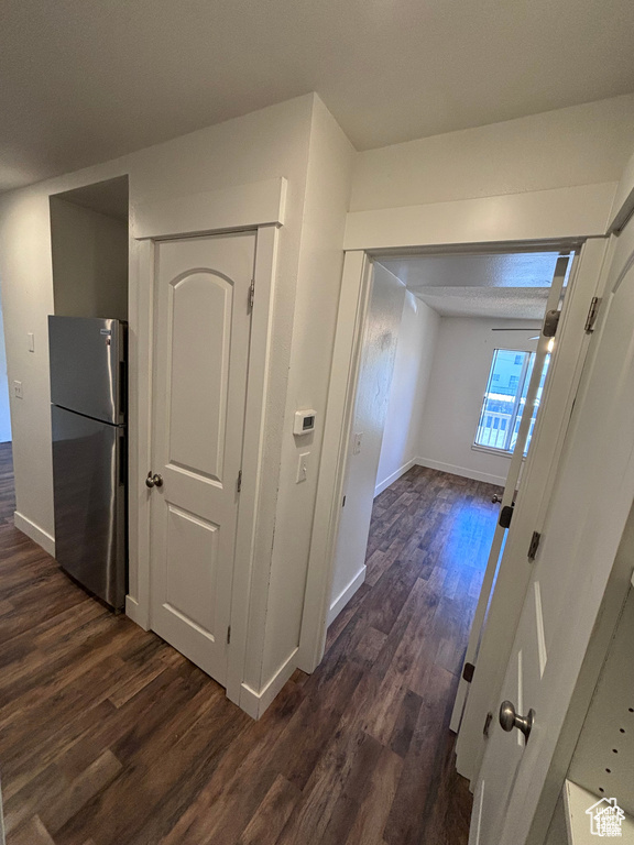 Hallway featuring dark wood finished floors and baseboards