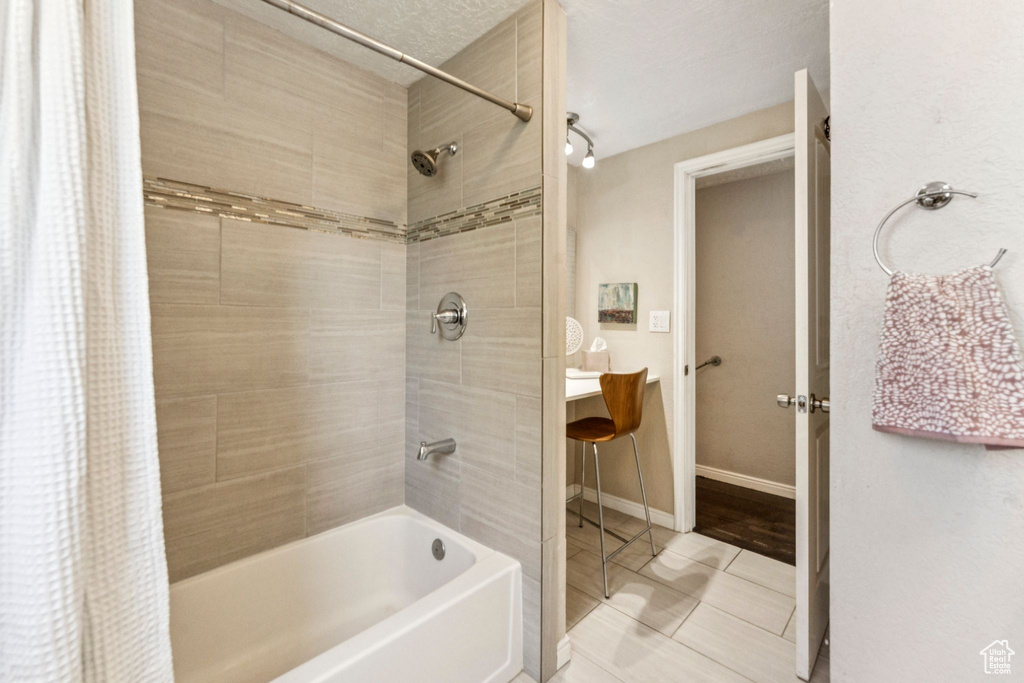 Bathroom with shower / bath combo, tile patterned flooring, and vanity