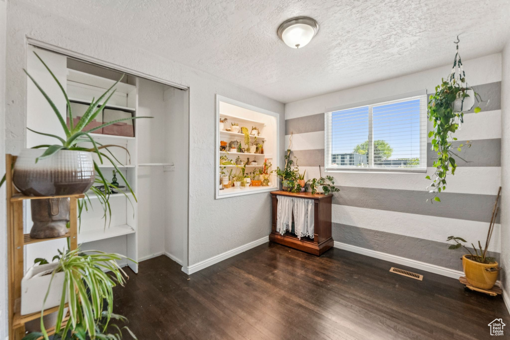 Unfurnished room featuring wood finished floors and a textured ceiling