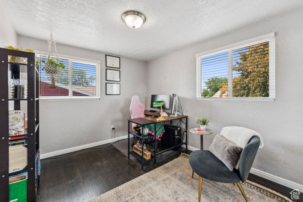 Home office featuring wood finished floors, a textured ceiling, and a textured wall