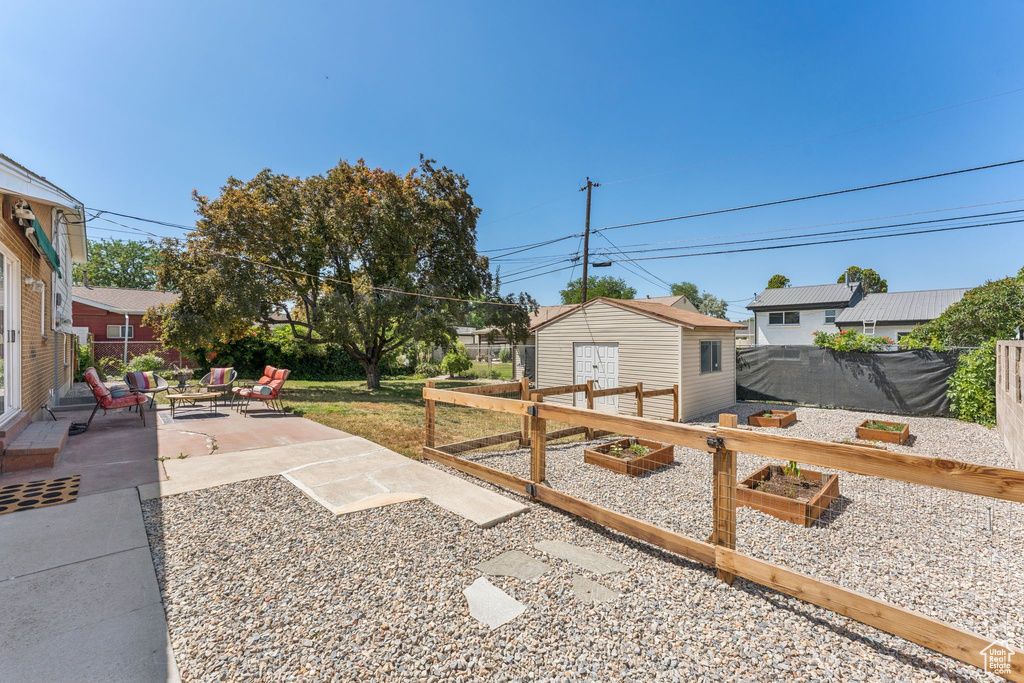 View of yard featuring a garden, a patio, and an outdoor structure