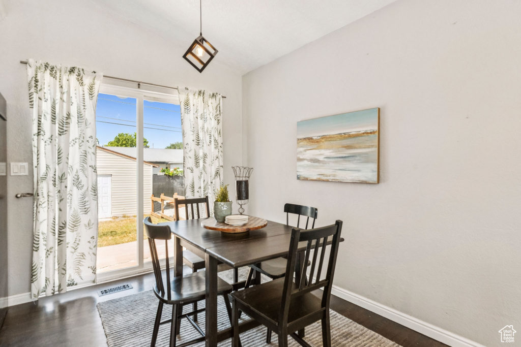 Dining area featuring dark wood-type flooring and lofted ceiling