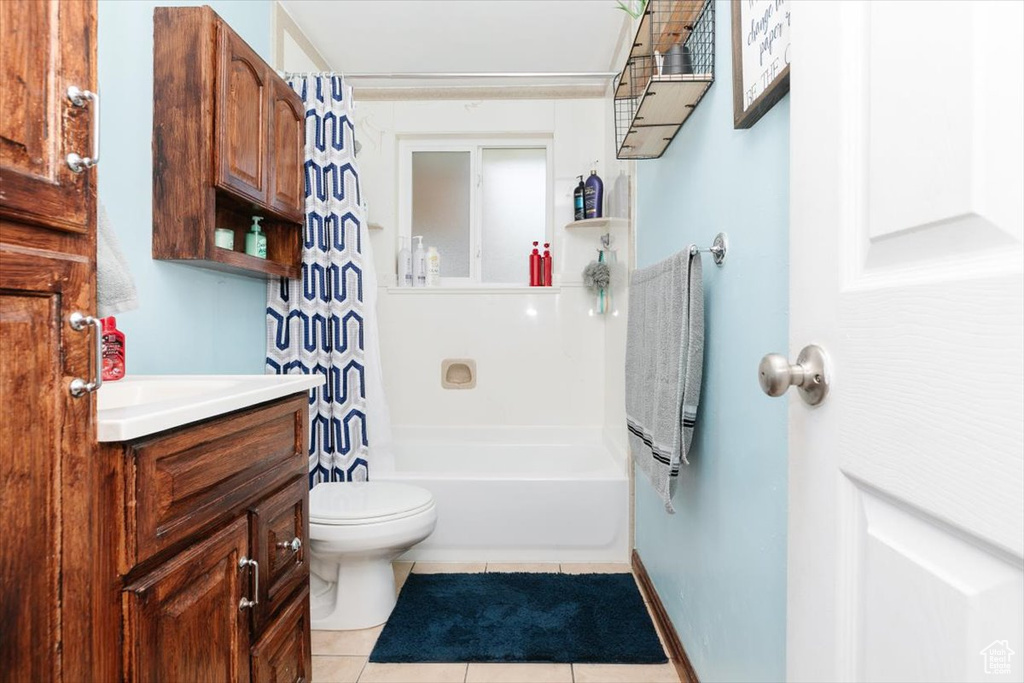 Full bath featuring tile patterned floors, vanity, and shower / tub combo with curtain