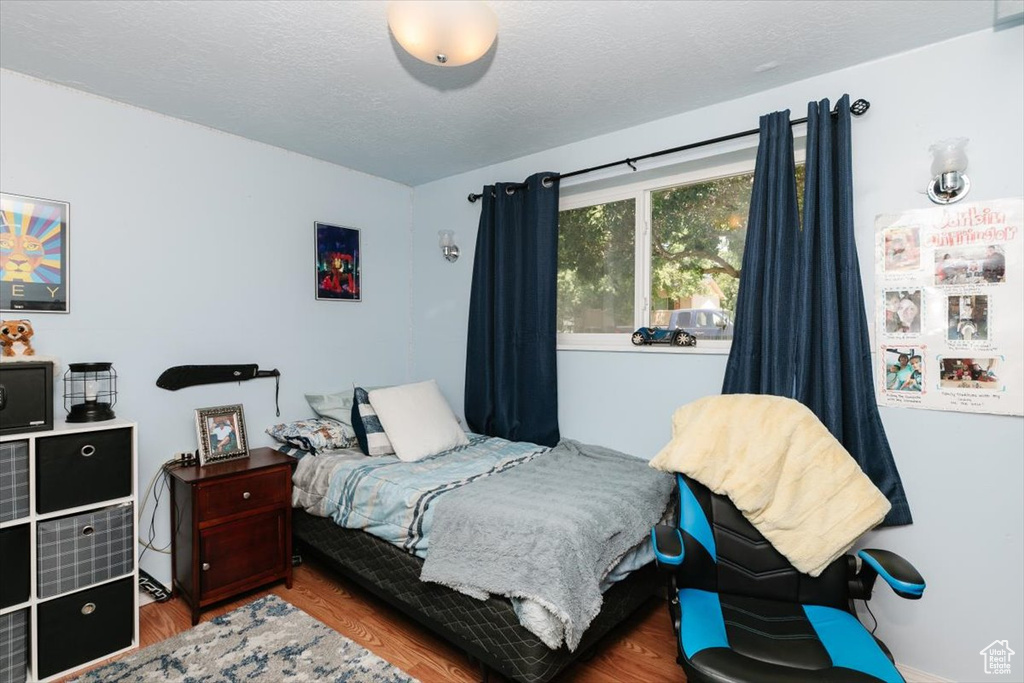Bedroom featuring wood finished floors and a textured ceiling