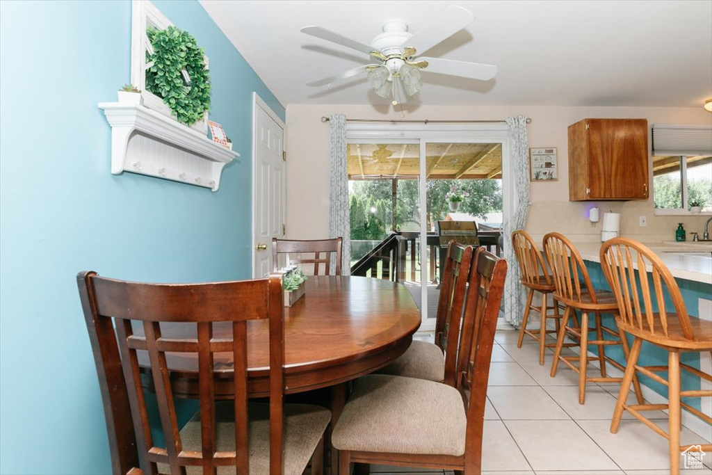 Dining area with ceiling fan and light tile patterned flooring