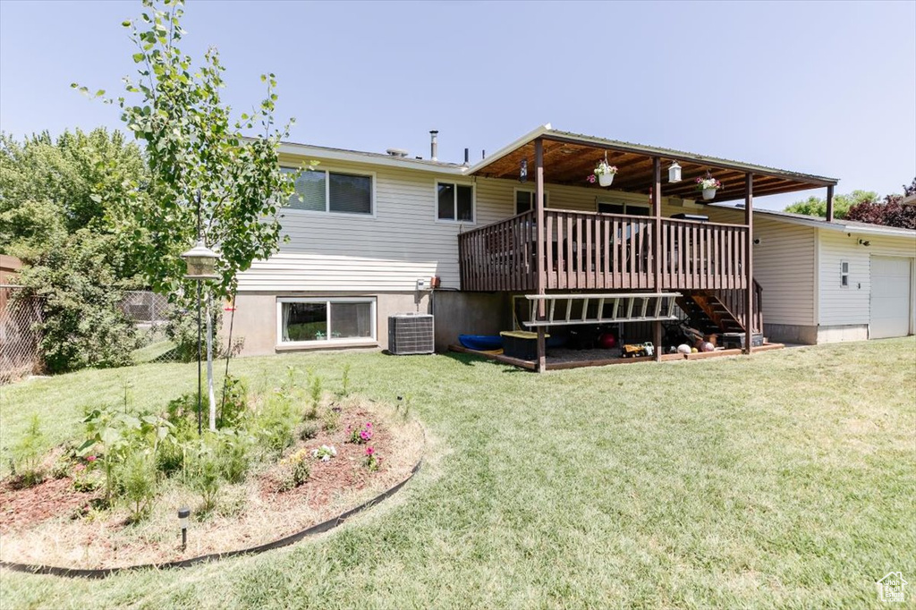 Rear view of property with stairs, a deck, and an attached garage
