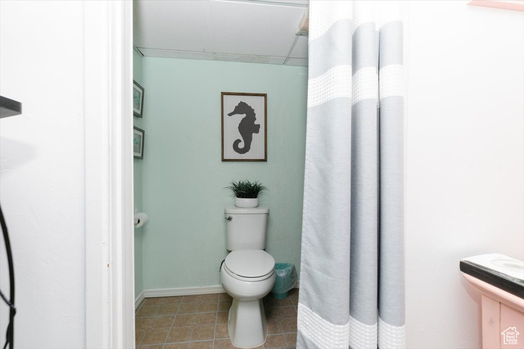 Full bathroom featuring tile patterned floors, curtained shower, and vanity