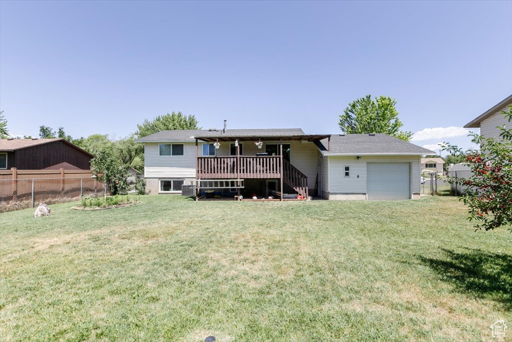 Back of house with a wooden deck, an attached garage, and stairs