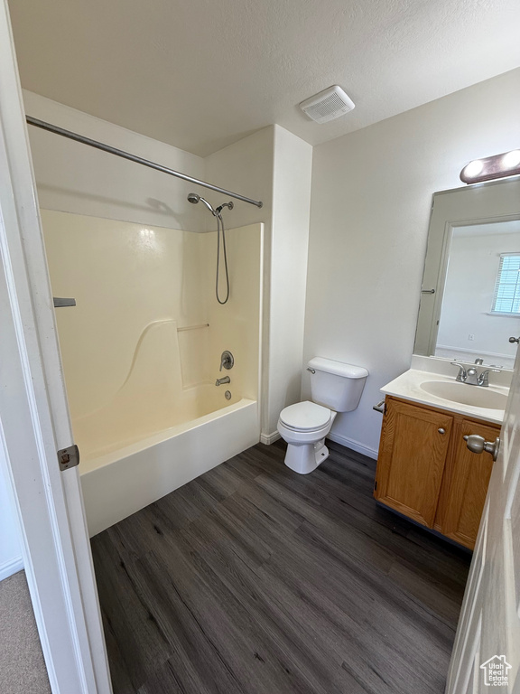 Bathroom featuring vanity, shower / tub combination, wood finished floors, and a textured ceiling