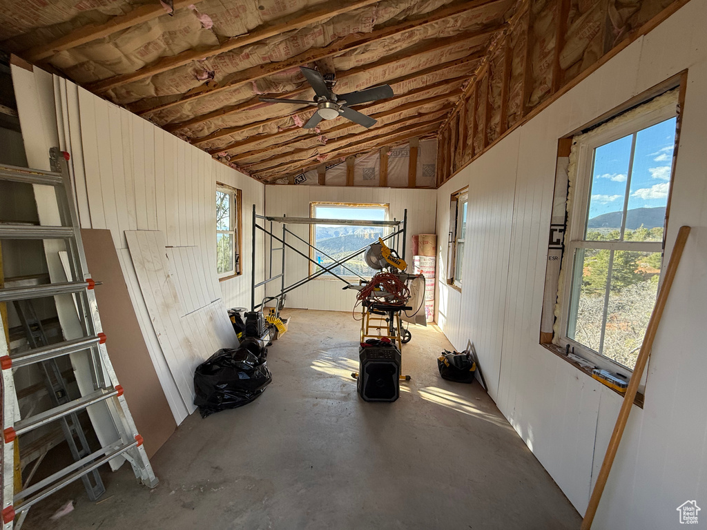 Misc room with a ceiling fan, vaulted ceiling, concrete floors, and a mountain view