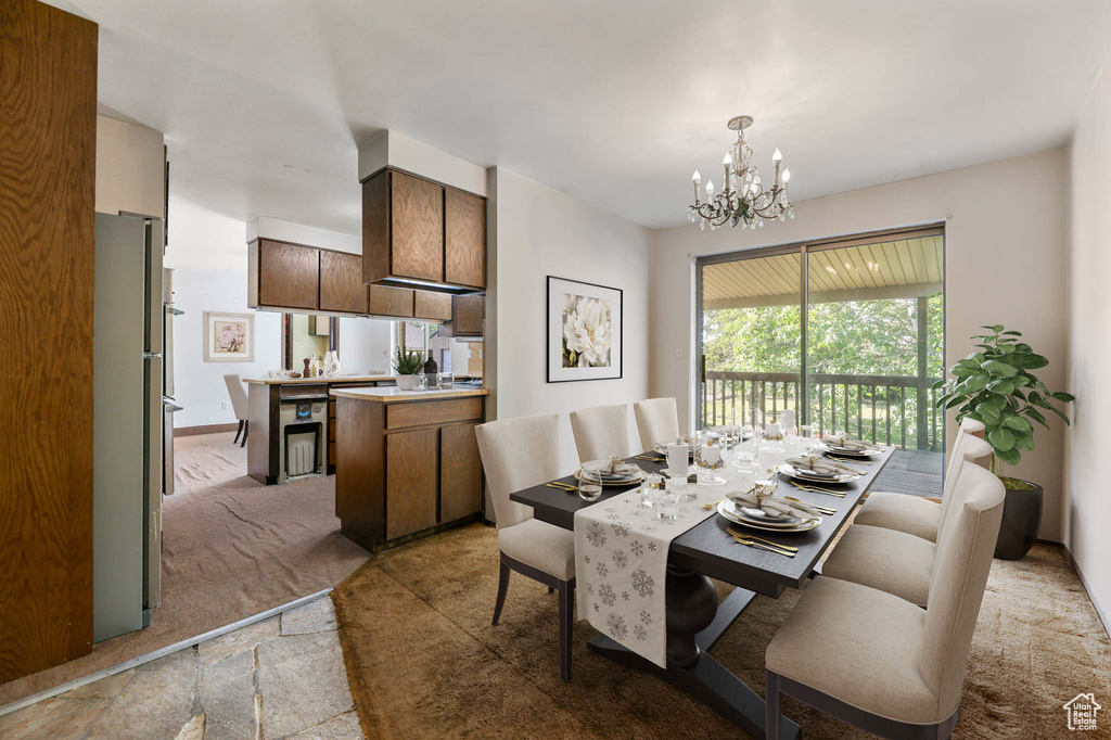 Dining area with a chandelier and light carpet
