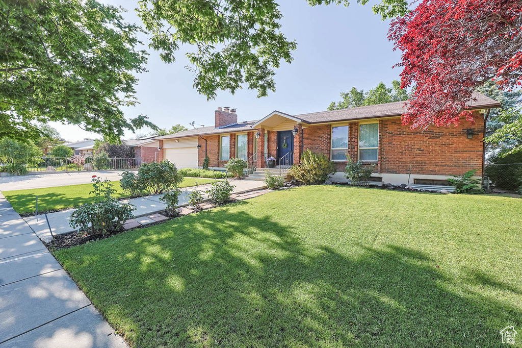 Single story home with brick siding, a chimney, concrete driveway, and a garage