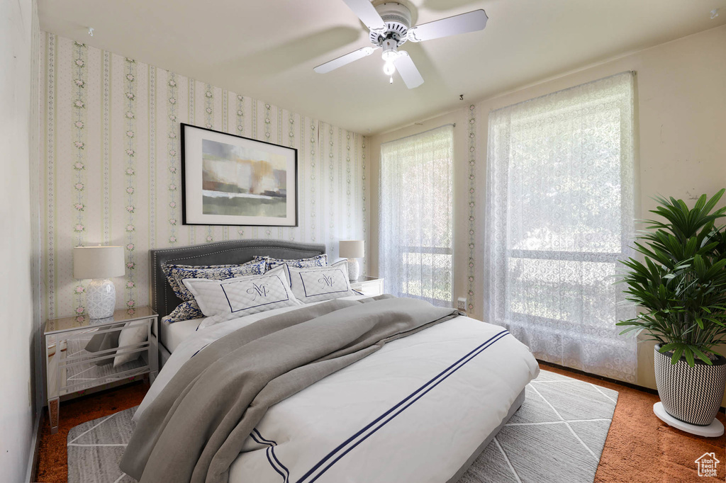 Bedroom with wallpapered walls and a ceiling fan