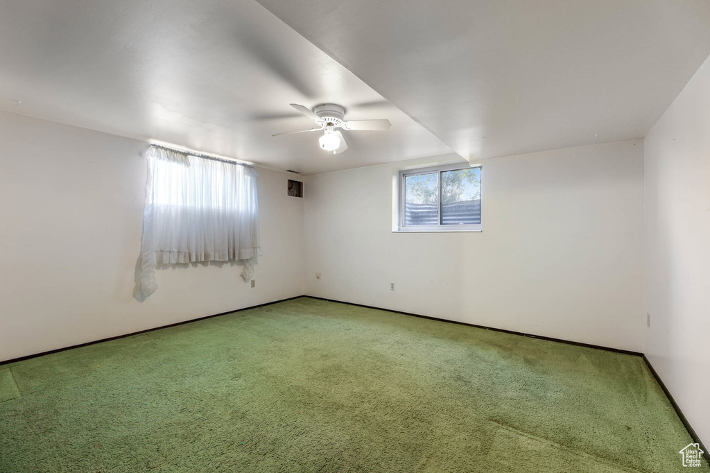 Spare room featuring light carpet and a ceiling fan