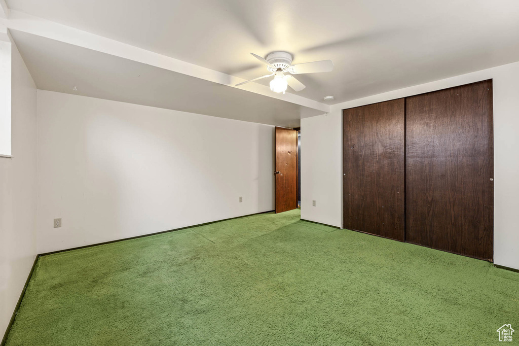 Unfurnished bedroom with light colored carpet, a closet, and a ceiling fan